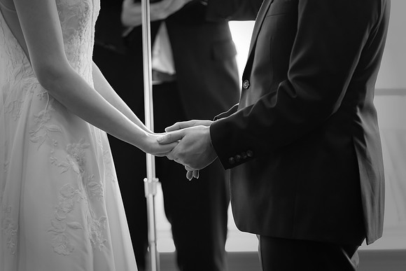 Bride and Groom are hand in hand at the Ceremony Black and White Photo