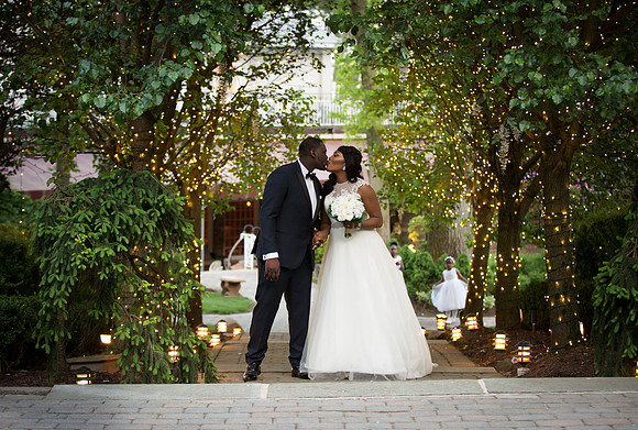 Beautiful Black Bride and Groom kissing under the string light at The Tides Estate